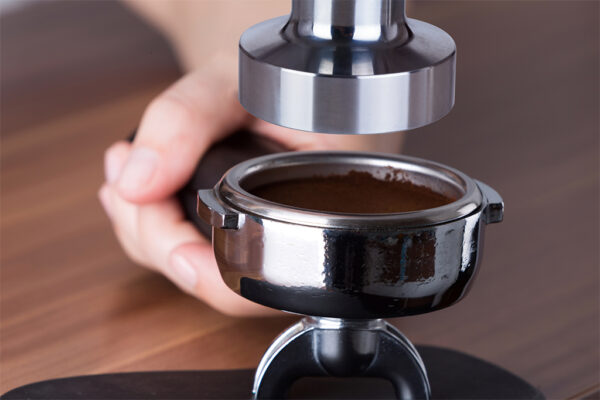 Process of tamping the coffee for espresso preparation